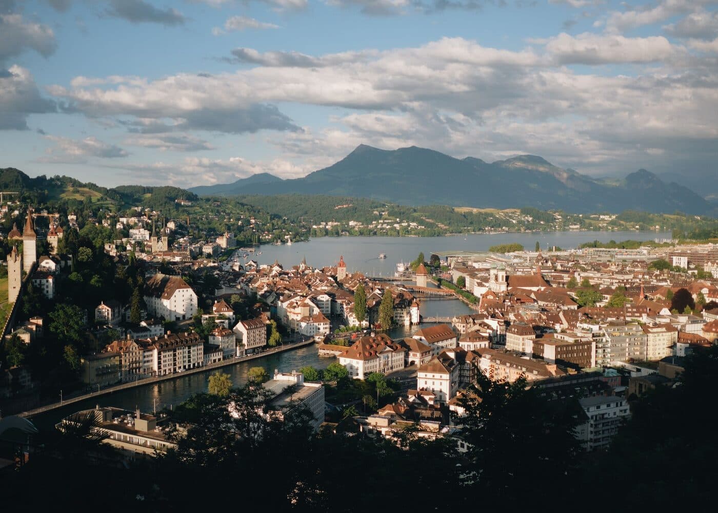 A Swiss town on a lake below snow-covered peaks