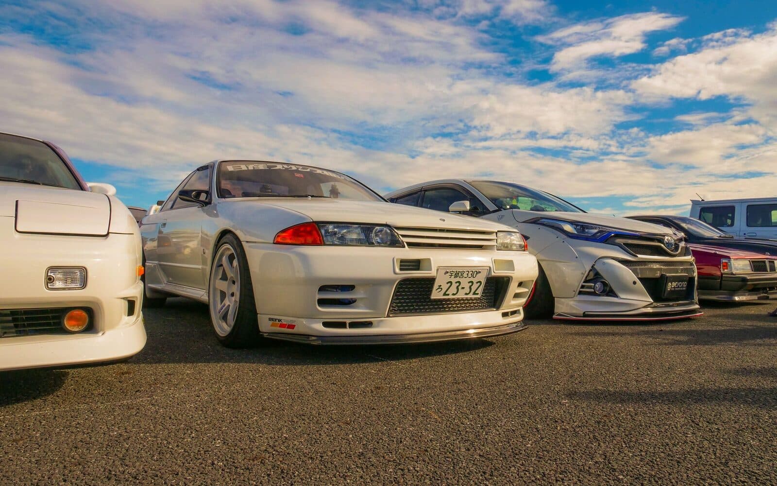 A line of Japanese performance cars at golden hour